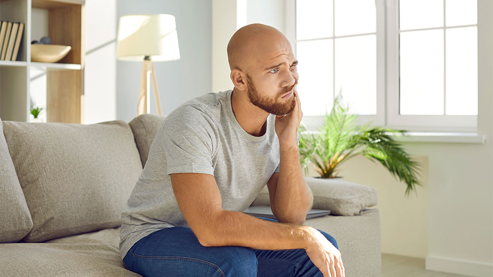 homme souffrant d'une douleur post opératoire endodontique